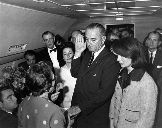 린든 존슨 전 대통령이 JFK 서거 이후 대통령 전용기에서 대통령 취임 선서를 하고 있다.
