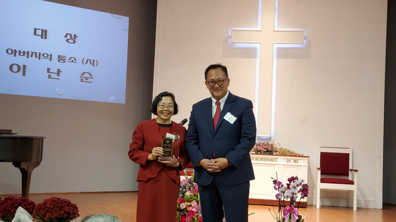 지난 14일 오후 둘루스 주님의영광교회에서 6회 신인문학상 대상 수상자인 이난순(왼쪽)씨가 조동안 회장과 기념촬영을 했다.