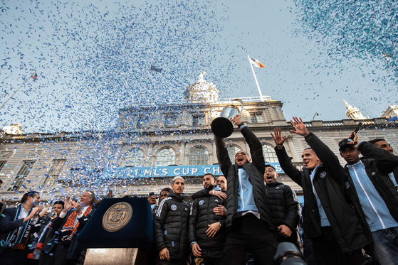 창단 첫 미국프로축구(MLS) 우승을 차지한 뉴욕시티FC(NYCFC)가 14일 뉴욕시청 앞에서 축하행사를 가졌다. NYCFC는 지난 11일 오리건주 포틀랜드의 프로비던스파크에서 열린 포틀랜드 팀버스와의 MLS컵 결승에서 전·후반 1 대 1 동점 상황에서 연장전에 돌입, 승부차기(4 대 2) 끝에 우승을 결정지었다. 14일 NYCFC 선수들이 우승컵을 들고 환호하고 있다. [뉴욕시장실]