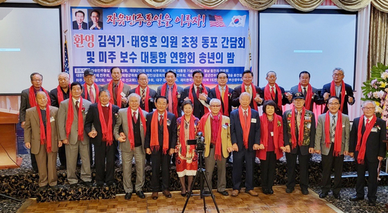  지난 13일 LA한인타운 가든스위트 호텔에서 열린 LA보수 대통합 송년회에서 참석한 인사들이 재외선거 유권자 등록을 독려하며 기념촬영을 하고 있다. [임태랑씨 제공]