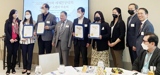 세계한상대회 OC 유치를 지지하는 정치인 보좌관들이 LA총영사관, 재외동포재단 실사단 관계자에게 감사장을 전달하고 있다. 왼쪽 두 번째부터 이희경 영사, 정광일 실사단장, 한 사람 건너 오른쪽으로 실사단 강모세 부장, 김수빈 대리. 서 있는 이 중 맨 오른쪽이 노상일 OC상의 회장. 