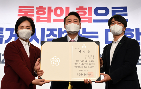 10일(한국시간) 오후 윤석열 대통령 당선인이 국회 도서관에서 열린 국민의힘 선대본부 해단식에서 청년 보좌역들로부터 당선증을 전달받고 있다. [연합]