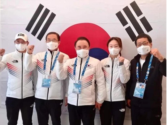 윤홍근(가운데) 제너시스BBQ 회장 겸 올림픽 선수단장이 베이징 동계올림픽 선수촌에서 최민정(오른쪽 두 번째) 국가대표 쇼트트랙 선수에게 대통령 축전을 전달하며 격려하는 모습. [제너시스BBQ그룹]