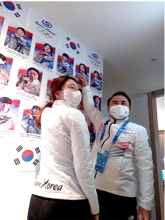 윤홍근(오른쪽) 제너시스BBQ 회장 겸 올림픽 선수단장과 최민정이 출정현황판에 은메달 스티커를 붙이며 기뻐하고 있다. [제너시스BBQ그룹]