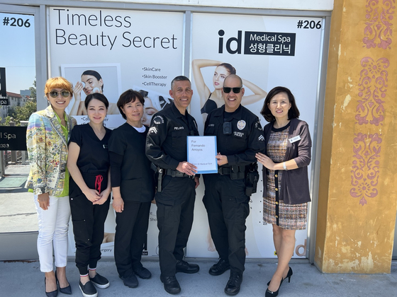 ID 메디컬 스파 관계자들이 펀드레이징 행사에 참여하는 올림픽 경찰서 (오른쪽에서 3번째부터) 조 팔라요와 에릭 몰리네도순찰반창에게 후원금을 전달하고 있다. 