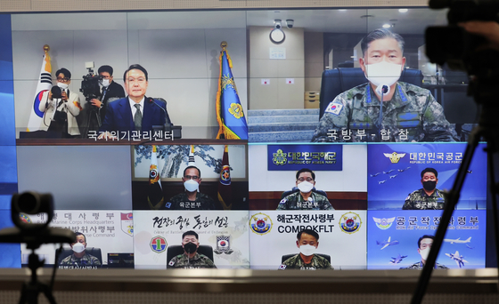 윤석열 대통령이 10일 0시(한국시간) 서울 용산 대통령실 국가위기관리센터 상황실에서 국군통수권을 이양받은 뒤 원인철 합동참모본부 의장으로부터 북한 군사 동향과 우리군 대비태세에 보고를 받으며 집무를 시작하고 있다.  [연합]
