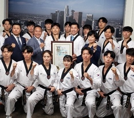 지난 2019년 LA시의회가 9월 4일을 태권도의 날로 지정하는 결의안을 채택한 후 한국 국기원 태권도 시범단들과 결의안을 주도한 데이비드 류 전 시의원이 기념 촬영을 하고 있다. [가주태권도위원회 제공]