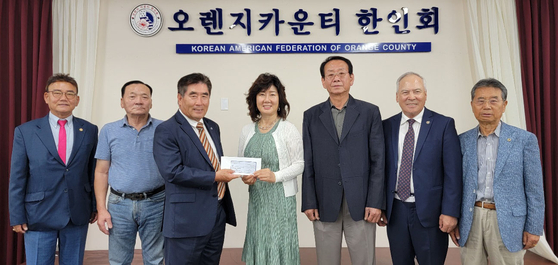 오렌지카운티 호남향우회가 우크라이나 난민 돕기 성금 2000달러를 25일 OC한인회에 전달했다. 장정순 OC호남향우회장(가운데)이 두 단체 관계자들이 지켜보는 가운데 권석대 OC한인회장(장 회장 왼쪽)에게 회원들이 모은 성금이 든 봉투를 건네고 있다. [OC한인회 제공]