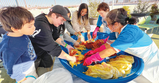 지난 22일 LA 한인타운 YMCA에서 열린 ‘아이러브김치 페스티벌’ 김치의 날 행사에서 참가자들이 절임 김치에 김칫소를 버무리고 있다. 김상진 기자 