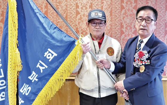 대한민국 재향군인회 미동북부지회가 9일 퀸즈 베이사이드 삼원각 식당에서 2023년 개선 총회를 열고 배광수 신임 회장(왼쪽)을 선출했다. 황재헌 전임 회장(오른쪽)이 배 신임 회장에게 협회기를 이양하고 있다.  [재향군인회 미동북부지회]