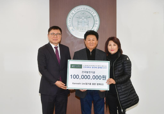 엄기홍(중간)씨와 아내 애니 엄(오른쪽)씨가 건국발전기금 1억원을 건국대 전영재 총장(왼쪽)에게 전달하고 있다. [건국대학교 제공]