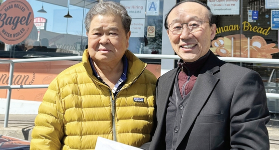 바울선교회(회장 송기수) 전 회장 김성구 장로(왼쪽)는 3일 자신이 운영하는 노던불러바드 157스트리트 가나안제과 앞에서 한인노숙인 셸터 더나눔하우스 대표 박성원 목사에게 셸터 구입 후원금으로 1200달러를 전달했다. [더나눔하우스]