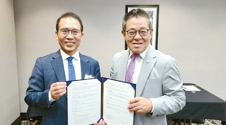 지난 15일 한상대회 공식 여행사로 선정된 푸른투어 이문식(오른쪽) 이사와 한상대회 조직위원회 노상일 본부장이 업무협약서를 교환하고 함께 자리했다. [한상대회 조직위 제공]