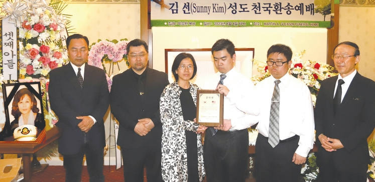 김선 6·25참전유공자회 뉴욕지회 총무의 장례식이 지난 8일 플러싱 마틴 글리손 장례식장에서 거행됐다. 유가족들이 6.25참전유공자회 뉴욕지회 강석희 초대 회장이 김선 총무에게 증정한 감사패를 들고 고인을 회고하고 있다.  [6·25참전유공자회 뉴욕지회]