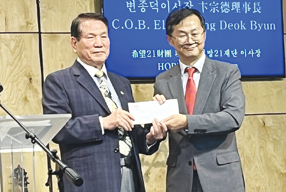 21희망재단이 지난 3일 뉴욕농아인교회 창립 15주년 기념행사에 방문해 지원금 1000달러를 전달했다. 21희망재단 변종덕 이사장(왼쪽)은 축사를 통해 “15년 동안 농아들에게 복음을 전하는 농아인교회의 수고와 헌신에 감사를 표한다”고 전했다.  [21희망재단]