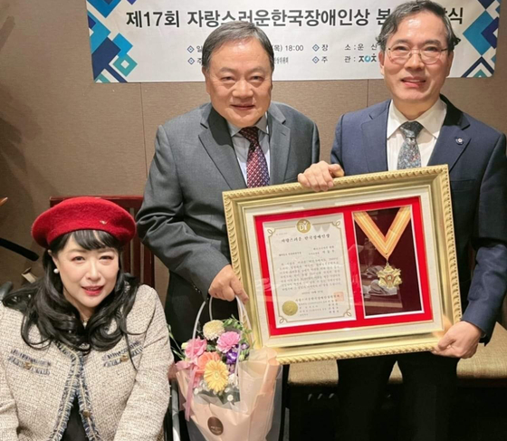 박동우(가운데) 보좌관이 제17회 자랑스런 한국 장애인상을 받고 있다. 왼쪽이 배은주 상임대표, 오른쪽은 최봉실 위원장. [총연 제공]