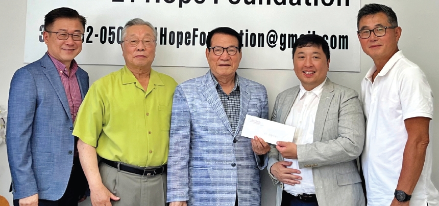 퀸즈 화잇스톤 뉴욕하모니교회(담임목사 윤상훈, 왼쪽 네 번째)가 26일 플러싱 비영리단체 21희망재단(이사장 변종석, 가운데)에 후원금 1000달러를 전달했다.  [21희망재단]