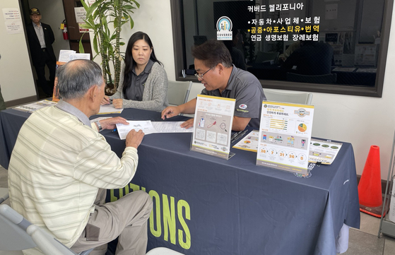 26일 OC한인회관에서 OC선거관리국 한인 커뮤니티 아웃리치 담당 데이비드 이(뒷줄 오른쪽부터), 코니 마르케스씨가 유권자 등록을 도와주고 있다.