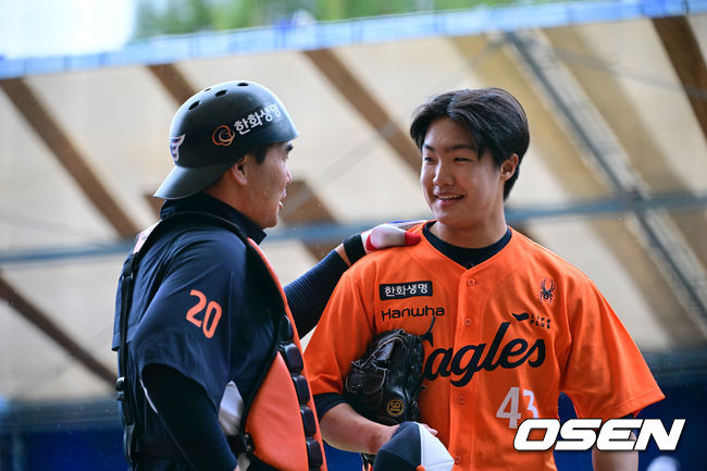 [OSEN=오키나와(일본), 조은정 기자]한화 이글스가 21일(한국시간) 일본 오키나와 온나손 아카마 구장에서 삼성 라이온즈와의 연습경기 우천 취소 후 훈련을 가졌다.한화는 21일 훈련을 시작으로 8차례 연습경기를 치른 뒤 내달 4일 귀국한다.한화 투수 정우주가 불펜피칭을 마친 뒤 포수 이재원과 대화를 나누고 있다. 2025.02.21 /cej@osen.co.kr