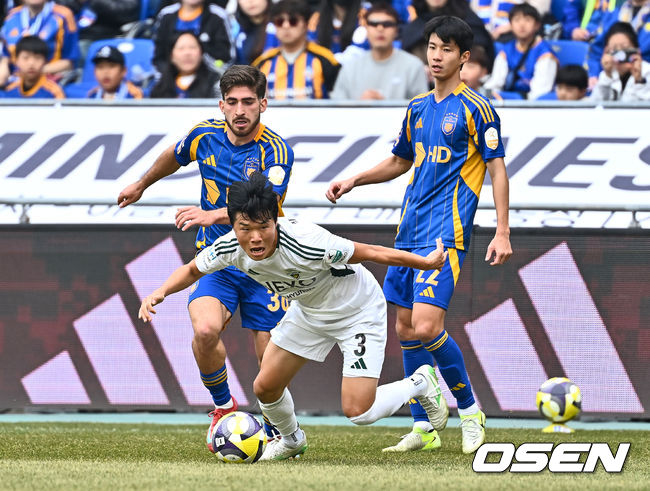 [OSEN=울산, 이석우 기자] 1일 울산 문수축구경기장에서 하나은행 K리그1 2025 울산 HD와 전북 현대의 경기가 열렸다.  세대교체를 시도하는 김판곤 감독의 울산과 공격 축구의 부활을 노리는 포옛 감독의 전북이 첫 ‘현대가 더비’를 갖는다. 전북 현대 최우진이 울산 HD 라카바의 수비를 피해 공격하고 있다. 2025.03.01 / foto0307@osen.co.kr