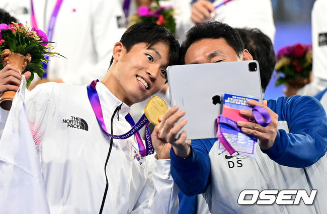 [OSEN=항저우(중국), 최규한 기자] 모든 역경을 뚫어내고 황선홍호가 금메달을 거머쥐었다.황선홍(55) 감독이 이끄는 대한민국 아시안게임 축구 국가대표팀은 7일 오후 9시(이하 한국시간)부터 중국 항저우의황룽 스포츠센터 스타디움에서일본과 2022 항저우 아시안게임 결승전을 치러 2-1로 승리했다.금메달을 거머쥔 한국 정우영이 스태프와 함께 기념촬영을 하고 있다. 2023.10.01 / dreamer@osen.co.kr