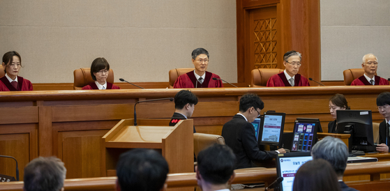 문형배 헌법재판소장 권한대행(가운데)이 지난 4일 서울 종로구 헌법재판소 대심판정에서 윤석열 대통령 탄핵심판 인용 결정문을 낭독하고 있다. 사진공동취재단