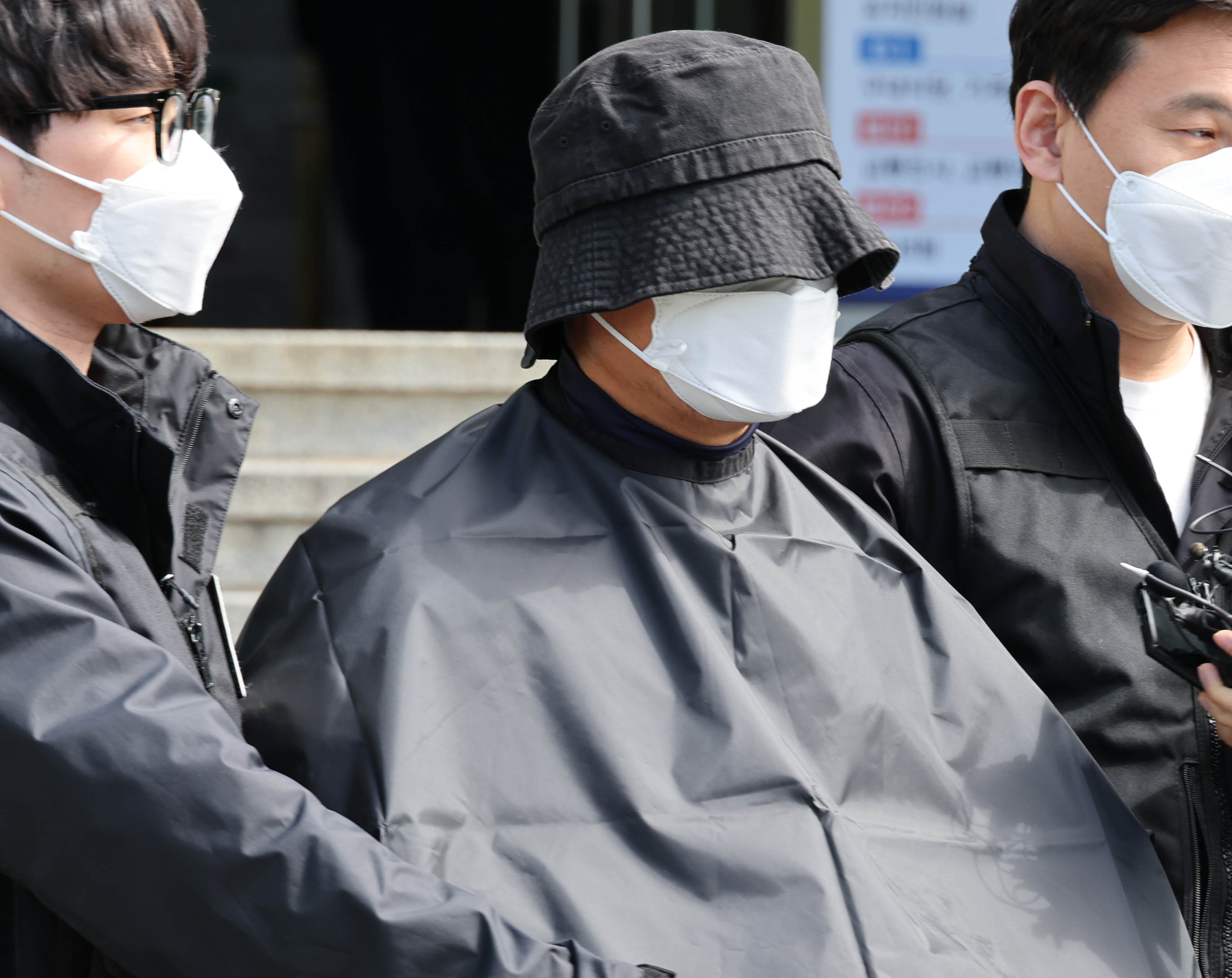부산 법원 앞에서 생방송하던 유튜버를 살해한 혐의(특가법상 보복살인)를 받는 50대 유튜버가 지난해 5월 16일 오전 부산 연제경찰서에서 검찰 송치를 위해 이동하고 있다. 연합뉴스