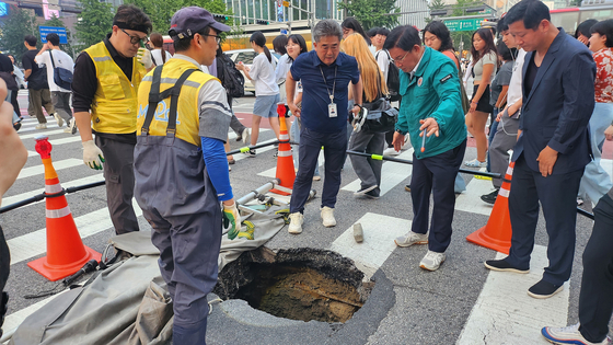 마포구 서교동 일대 도로 침하 현장에서 도로 복구 작업을 진행 중인 마포구청 관계자. [사진 마포구]