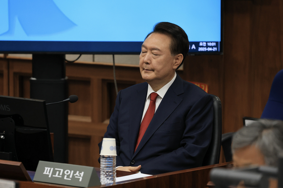 윤석열 전 대통령이 21일 오전 서울중앙지법 417호 법정에서 열린 내란 우두머리 혐의에 대한 2차 공판에 출석해 피고인석에 앉아 재판 시작을 기다리고 있다. [사진 사진공동취재단]