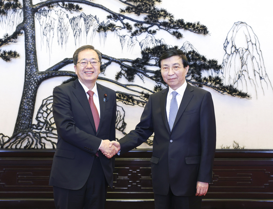 일본 사이토 데쓰오 공명당 대표(왼쪽)가 지난 23일 중국을 방문해 왕후닝 중국 정치국 상무위원 겸 전국정치협상회의 주석과 만나 악수를 나누고 있다. 신화=연합뉴스