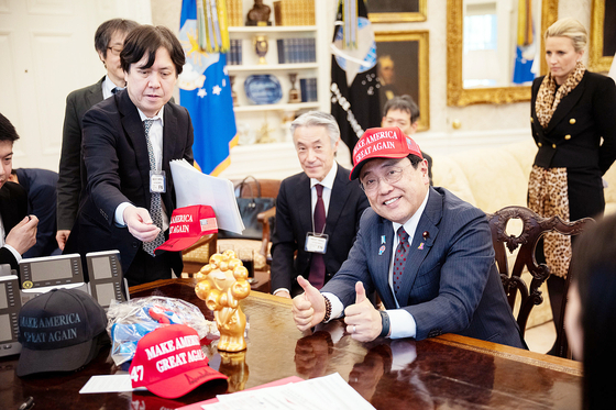 지난 16일 지난 16일 아카자와 료세이 일본 경게재생상이 도널드 트럼프 미국 대통령에게 받은 모자를 쓰고 엄지 손가락을 들어보이고 있다. 사진 백안관=지지통신