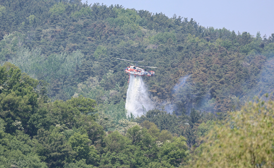 대구 북구 함지산 산불 이틀째인 29일 오후 산불 진화 작전에 투입된 산림청 산불 진화용 헬기가 함지산 상공에서 물을 뿌리고 있다. 뉴스1
