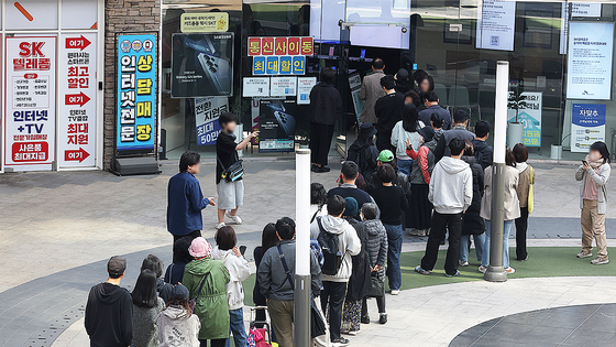 가입자 유심(USIM) 정보를 탈취당한 SK텔레콤이 유심 무료교체 서비스를 시작한 지 이틀째인 29일 서울 시내 한 SKT 대리점에 시민들이 줄을 서서 교체를 기다리고 있다. 연합뉴스