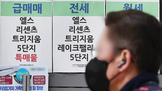 지난 3월 서울 송파구의 한 부동산 중개사무소 앞을 시민이 지나고 있다. [연합뉴스]