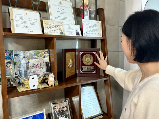4월 22일 서울 서대문구 자택에서 고(故) 유재국 경위의 아내 이꽃님(38)씨가 유 경위의 초상이 새겨진 기념패를 어루만지고 있다. 한강경찰대 소속 유 경위는 지난 2020년 2월 한강 투신자를 수색하다 순직했다. 이아미 기자
