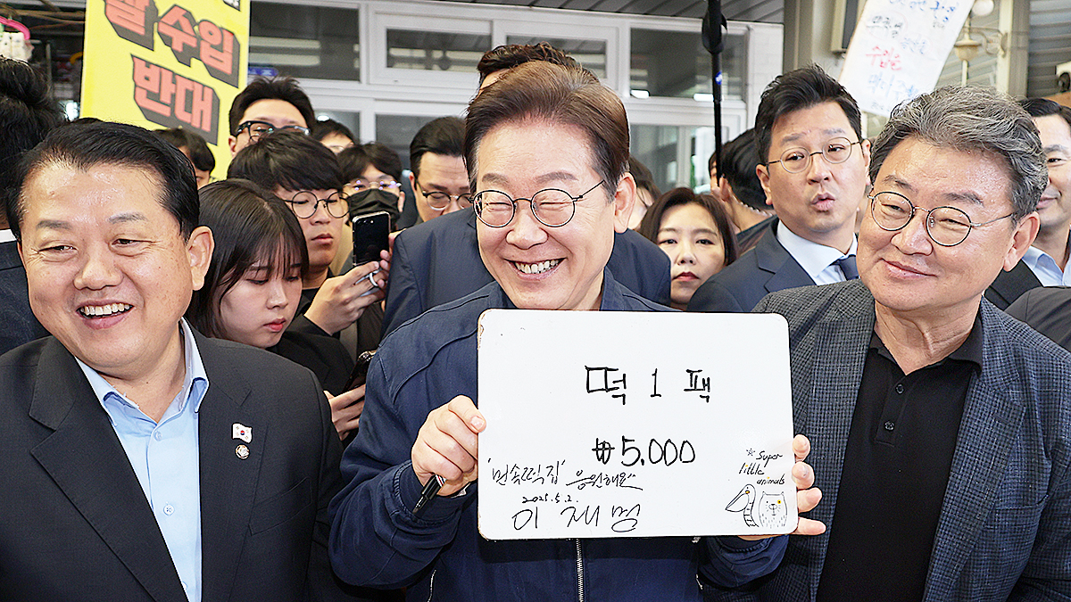 더불어민주당 이재명 대선 후보가 2일 강원도 철원군 동송전통시장에서 한 떡집에 들러 가격판에 사인을 해준 뒤 활짝 웃고 있다. 연합뉴스