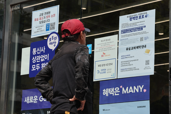 SK텔레콤이 가입자 유심(USIM) 정보 유출 사태로 오는 5일부터 신규 가입자 모집을 중단한다고 밝힌 2일 서울 시내의 한 SK텔레콤 대리점 앞에서 한 소비자가 유심 재고 소진 및 유심보호서비스 관련 안내문을 살펴보고 있다. 연합뉴스