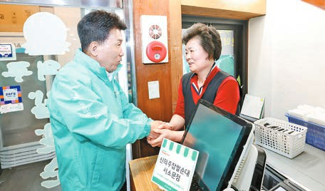 함영주 하나금융지주 회장이 소상공인 사업장을 방문해 악수를 하고 있다. 함 회장은 지난달 25일 국내외 주주들로부터 81.2%의 지지를 얻으며 연임에 성공했다. [사진 하나금융지주]