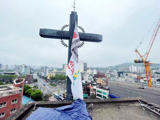 1일 서울 종로구 소재 혜화동성당의 종탑 위 십자가에 전국탈시설장애인연대 깃발이 걸려 있다. 사진 전국탈시설장애인연대
