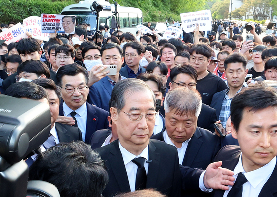 2일 오후 광주 북구 국립5·18민주묘지를 찾은 한덕수 전 총리가 광주비상행동 등 시민사회단체 관계자들에게 가로막히자 발길을 돌리고 있다. 연합뉴스