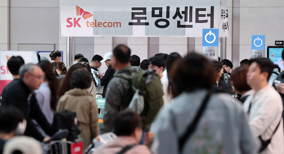 황금연휴를 앞둔 2일 오전 인천국제공항 제1여객터미널 출국장에 마련된 SK텔레콤 로밍센터에서 여행객들이 유심 교체 서비스를 받기 위해 대기하고 있다. 뉴스1