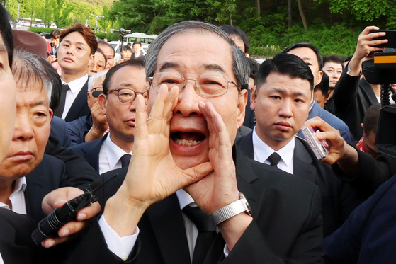지난 2일 오후 광주 북구 국립 5·18 민주묘지를 찾은 한덕수 전 총리가 광주비상행동 등 시민·사회단체 관계자들의 반발에 가로 막히자 "저도 호남 사람"이라며 호소하고 있다. 연합뉴스