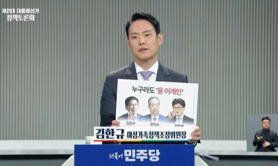 김한규 더불어민주당 의원이 지난 2일 중앙선거관리위원회가 주관한 대선 정책 토론회에 참석해 김문수·한덕수 후보, 한동훈 전 국민의힘 대표의 이름·사진과 '누구라도 윤 어게인'이라는 문구가 인쇄된 팻말을 들어 보이고 있다. 사진 김한규 페이스북