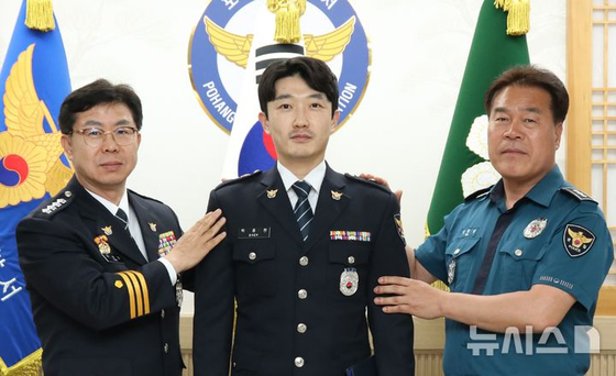 지난달 산불 당시 인명 구조로 1계급 특별승진 한 백종현 경위(가운데). [사진 포항남부경찰서]