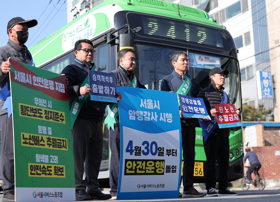 (서울=뉴스1) 김성진 기자 = 서울 시내버스 노조가 준법투쟁을 재개한 7일 오전 서울 성동구 태진운수 앞에서 노조원들이 버스교섭 타결을 촉구하며 피켓 시위를 하고 있다. 준법운행은 승객이 탑승 후 자리에 앉는 등 안전이 확보된 것을 확인 후 출발하거나, 앞서가는 차를 추월하지 않는 식의 방법으로 버스의 연착을 유도하는 방식이다. 2025.5.7/뉴스1