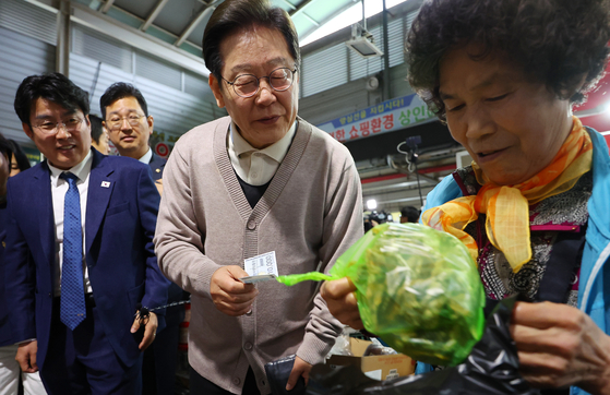 이재명 더불어민주당 대선 후보가 제3차 골목골목 경청투어로 경북지역 방문에 나선 9일 경북 영천시 영천공설시장을 찾아 한 가게에서 영천사랑상품권으로 말린 고추를 구매하고 있다. 연합뉴스
