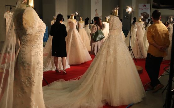 2020년 부산에서 열린 제46회 대한민국웨딩산업박람회'에서 업체 관계자들이 웨딩드레스 제품을 살펴보고 있다. 송봉근 기자