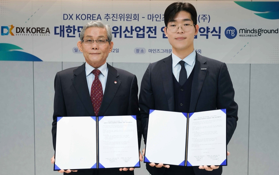 민환기 마인즈그라운드 대표(사진 오른쪽)와 김영후 DX KOREA 2026 추진위원회 위원장이 12일 '대한민국 방위산업전(DX KOREA) 2026 업무협약서'를 체결한 후 기념촬영을 하고 있다. 사진 마인즈그라운드