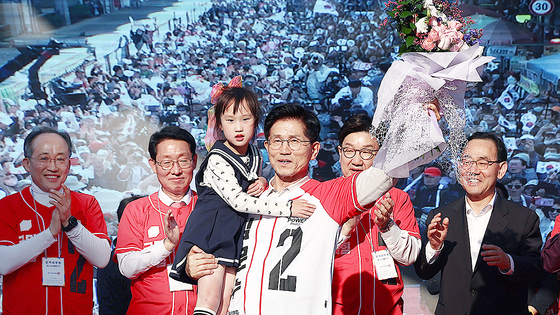 제21대 대통령 선거 공식 선거운동 첫날인 12일 김문수 국민의힘 대통령 후보가 대구 중구 서문시장에서 유세도중 어린이와 손을 들어보이고 있다. 뉴스1