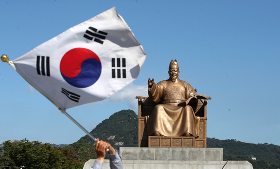 지난해 10월9일 서울 종로구 세종로 세종대로 광화문광장 세종대왕 동상 앞에서 한 시민이 태극기를 흔들고 있다. 뉴스1